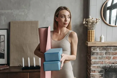 Žena s podložkou a pomôckami na cvičenie